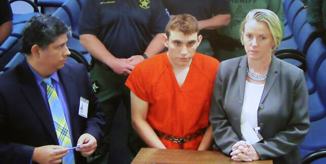 Nikolas Cruz (C) appears via video monitor with Melisa McNeill (R), his public defender, at a bond court hearing after being charged with 17 counts of premeditated murder, in Fort Lauderdale, Florida, U.S., February 15, 2018. REUTERS/Susan Stocker/Pool